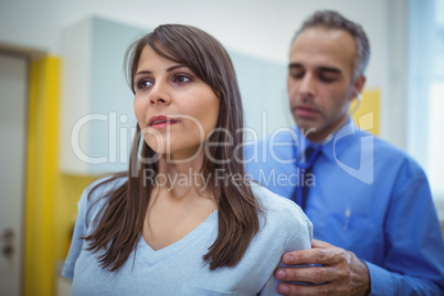 Doctor examining a female patients back