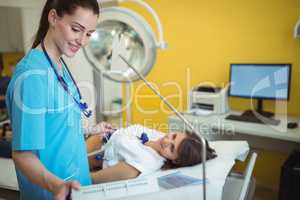 Nurse performing an electrocardiogram test on the patient