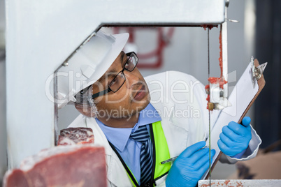 Technicians examining meat band saw
