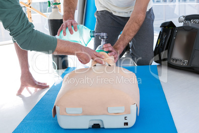 Paramedics practicing cardiopulmonary resuscitation on mannequin