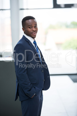 Businessman standing with hands in pocket in office