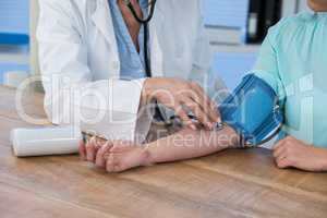 Female doctor checking blood pressure of a patient