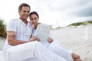 Happy couple using digital tablet on beach