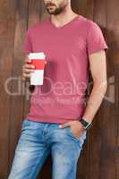 Man in pink t-shirt holding a disposable coffee cup