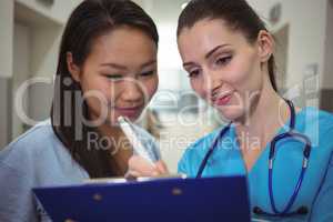 Female nurse assisting patient on clipboard