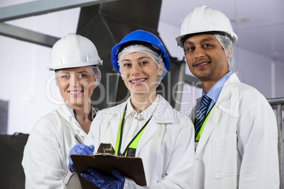 Team of technicians standing in meat factory