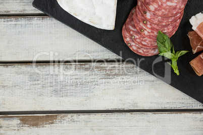 Salami and sliced meat on slate board