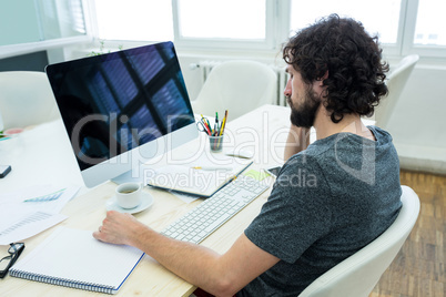 Graphic designer writing in a diary at his desk