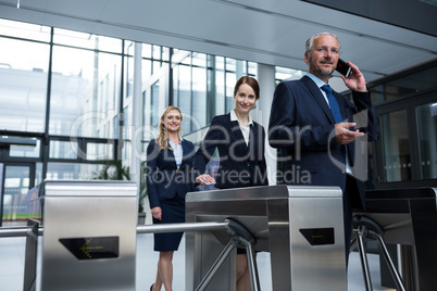 Businesspeople scanning their cards at turnstile gate