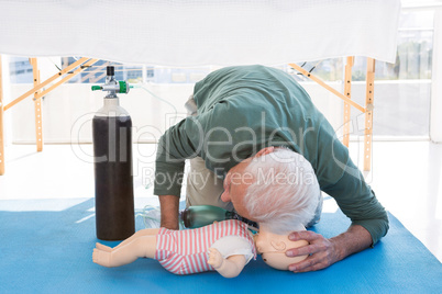 Paramedic practicing resuscitation on dummy