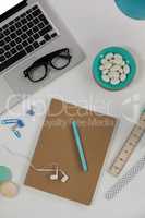 Laptop, spectacles, earphones, macaroons and office desk tops