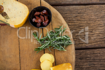 Variety of cheese and rosemary on wooden board