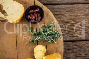 Variety of cheese and rosemary on wooden board