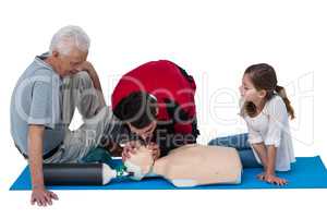 Paramedic training cardiopulmonary resuscitation to senior man and girl