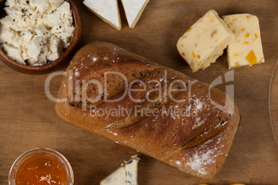 Variety of cheese with bread and sauce on chopping board