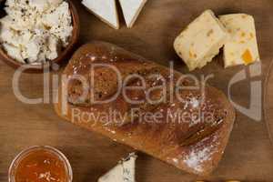Variety of cheese with bread and sauce on chopping board