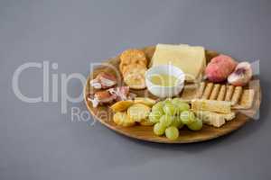 Variety of cheese with grapes, peach, meat and crackers