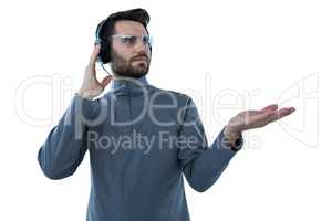 Man in protective glasses doing hand gestures while listening to headphones