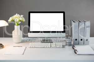 Desktop pc with flower vase and files