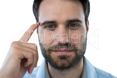 Man with finger pointing to head