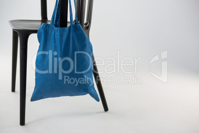 Blue bag hanging on a black chair