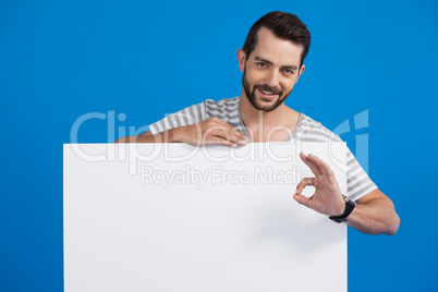 Handsome man holding a blank placard