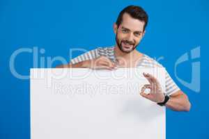 Handsome man holding a blank placard