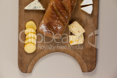 Variety of cheese with bread on chopping board