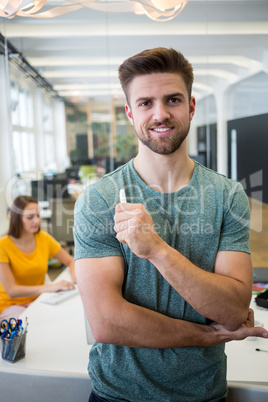 Portrait of smiling graphic designer standing with pen