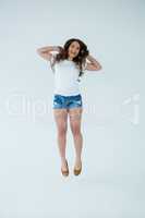 Cheerful woman in white t-shirt and hot pants jumping