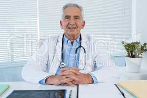 Portrait of smiling doctor sitting at table