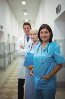 Portrait of female surgeon and doctors standing in corridor