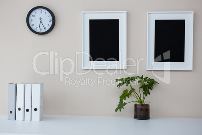 Picture frames and clock on wall