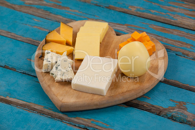 Variety of cheese on heart shaped chopping board