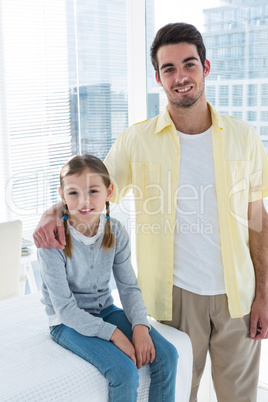 Portrait of girl sitting on the examination table with her father