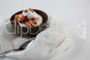 Brie cheese served with fruit slices and walnut in a bowl