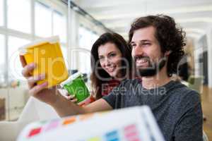 Graphic designers discussing over a container at their desk