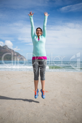 Excited woman jumping on beach