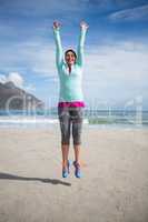 Excited woman jumping on beach