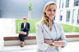 Businesswoman standing with arms crossed in office premises