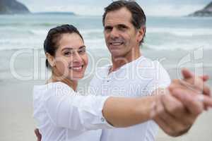 Portrait of romantic couple dancing on beach