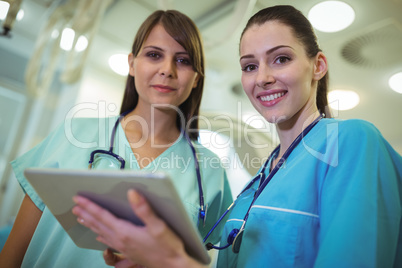 Portrait of two female surgeon using digital tablet