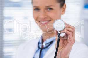 Smiling female doctor showing stethoscope