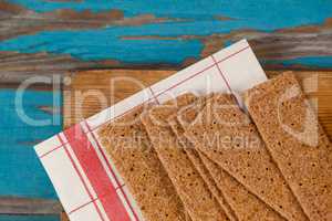 Crispy biscuits with tissue paper on wooden board