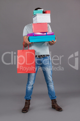 Man holding stack of gift boxes and shopping bag