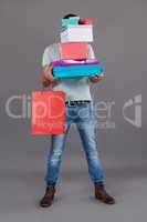 Man holding stack of gift boxes and shopping bag