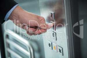 Hand of a businessman pressing the button in an elevator