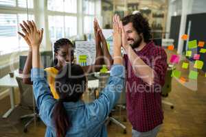 Team of business executives giving high five