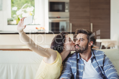 Romantic couple relaxing on sofa and taking a selfie