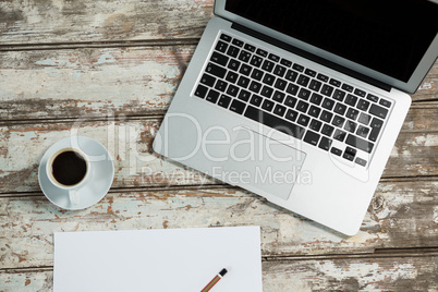 Laptop, blank sheet of paper, smartphone and coffee cup